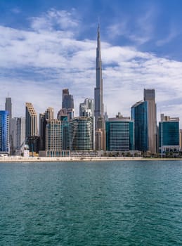 Dubai, UAE - April 2, 2023: Skyline of downtown district from water level in Business Bay