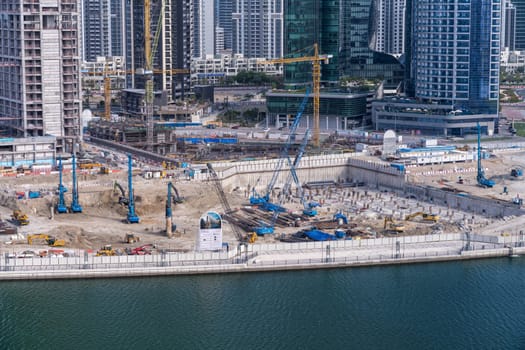 Dubai, UAE - April 1, 2023: Construction of the foundations of new tower for apartments along canal in Business Bay