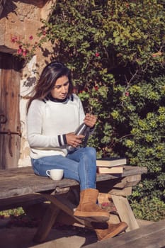 woman puts down the reading books and pours a cup of tea from the thermos, in the open air,