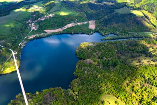 Spectacular aerial view from a drone to a lake and a road between hills.