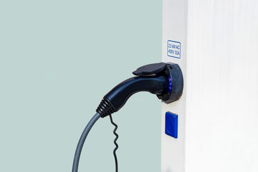 Closeup of charger plug to an electric vehicle from charging station. 