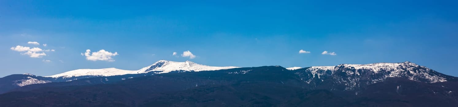 Amazing panorama with snow-capped mountains and hills