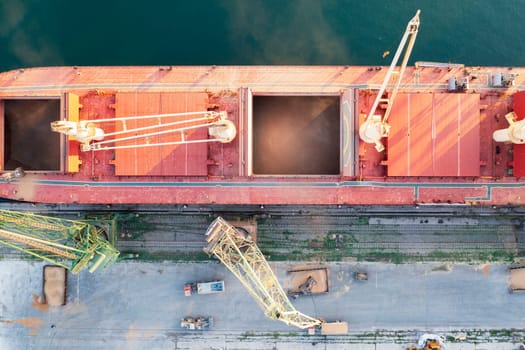 Top view from a drone of a large ship loading grain for export. Water transport