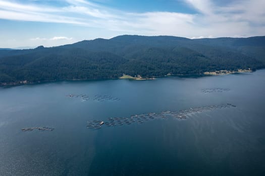 Aerial view of the mountain lake with  fish farms