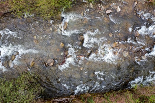 Aerial top view of flowing mountain river