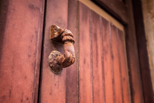 Door knocker. Old antique metal knocker on the wooden doors for knocking. Close up