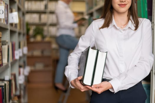 Close-up of female hands with books in public library