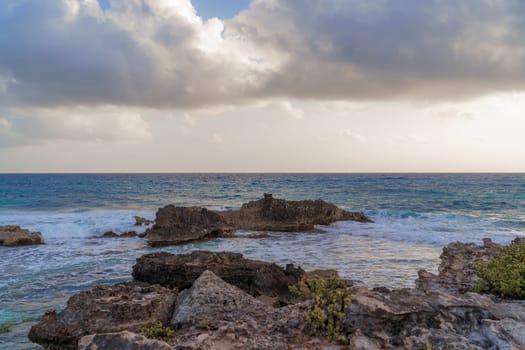 The coastline of the Caribbean Sea with white sand and rocks in Cancun.