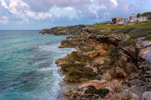 The coastline of the Caribbean Sea with white sand and rocks in Cancun.