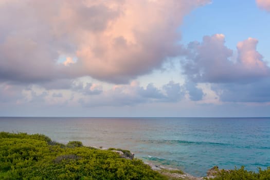 The coastline of the Caribbean Sea with white sand and rocks in Cancun.