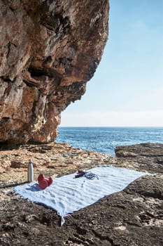Fitness and sports concept background. Getting ready. Towel, jump rope, dumbbell and bottle of water, by the sea on a sunny winter day, with beautiful blue sky
