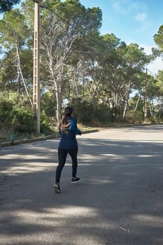 Latin woman, middle-aged, wearing sportswear, training, doing physical exercises, plank, sit-ups, climber's step, burning calories, keeping fit, outdoors by the sea, wearing headphones, smart watch
