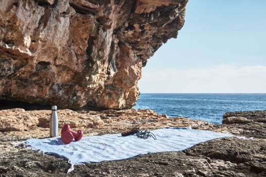 Fitness and sports concept background. Getting ready. Towel, jump rope, dumbbell and bottle of water, by the sea on a sunny winter day, with beautiful blue sky