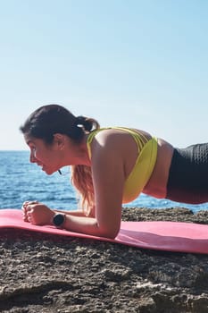 Latin woman, middle-aged, wearing sportswear, training, doing physical exercises, plank, sit-ups, climber's step, burning calories, keeping fit, outdoors by the sea, wearing headphones, smart watch