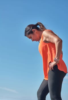 Latin woman, middle-aged, wearing sportswear, training, doing physical exercises, plank, sit-ups, climber's step, burning calories, keeping fit, outdoors by the sea, wearing headphones, smart watch