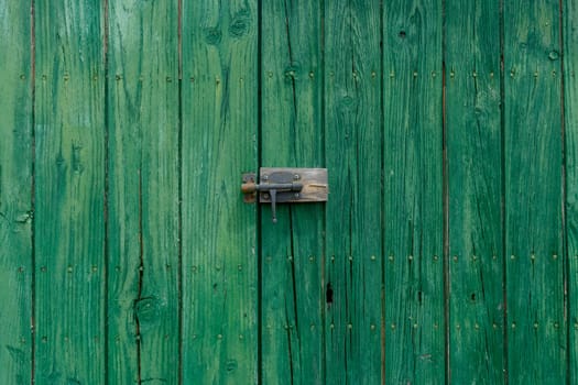 Old wooden door with aged metal door handle. Architectural textured background,