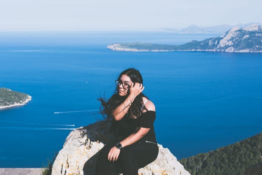 beautiful portrait of a young latin woman dressed in black in front of the sea