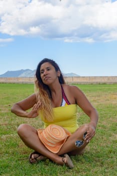 portrait of a latin woman smiling, having fun, on vacation in mallorca posing on a warm spring summer day, under a palm tree, hollidays concept,