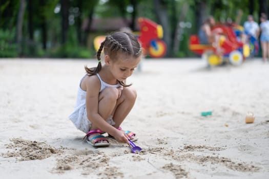 Little Girl Playing Sandbox Playground Digging Sand Shovel Building Sand Figure Summer Day. Caucasian Female Child 5 years Have Fun Outdoor