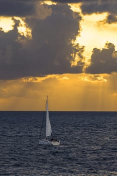 Yacht sailing in the open sea on a winter day. Dramatic stormy sky, dark clouds. Epic seascape. Mediterranean Sea, Spain, Balearic Islands, Majorca,,