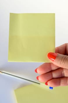 Woman's hand with painted nails holding blank letter paper on pure white background.