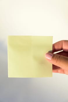 Woman's hand with painted nails holding blank letter paper on pure white background.