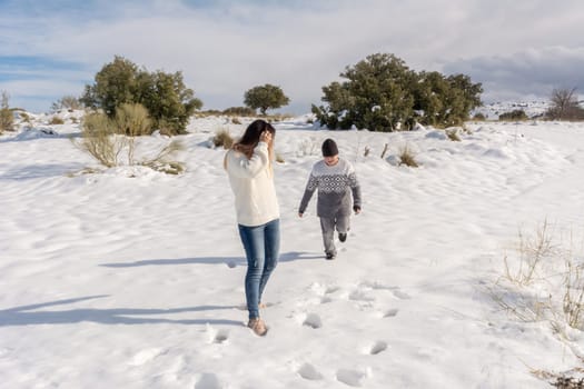 child and mother having fun in snowy landscape,