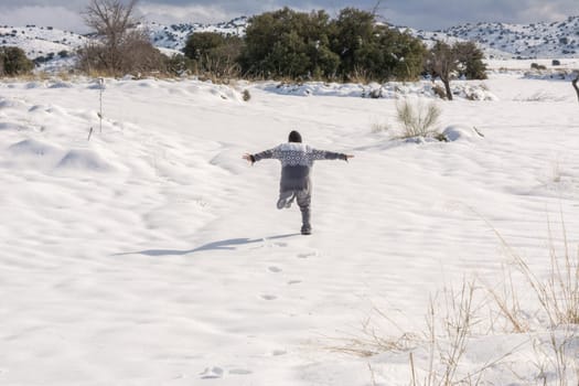 boy running and enjoying the snowy landscape,