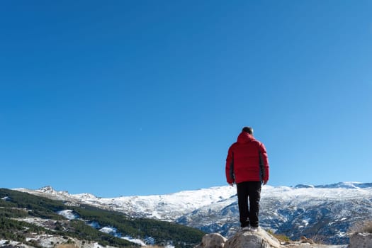 Man standing on the edge of a cliff and contemplating nature's creation in sierra nevada,