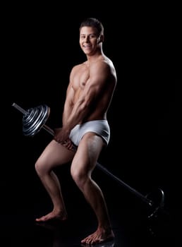 Funny sportsman posing sitting on barbell, isolated on black
