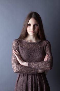Lovely brunette posing in lace dress on gray background, close-up