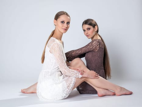 Pretty girls with long hair posing in stylish dresses