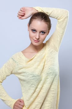 Portrait of pretty young girl posing in yellow blouse, close-up