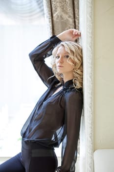 Portrait of pretty blonde in black chiffon blouse, close-up