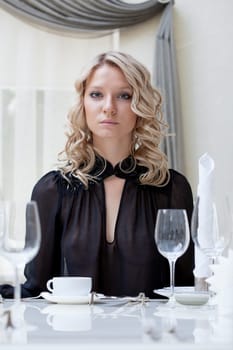Portrait of young attractive girl sitting at table, close-up