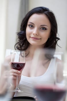 Pretty brunette posing with glass of red wine, close-up