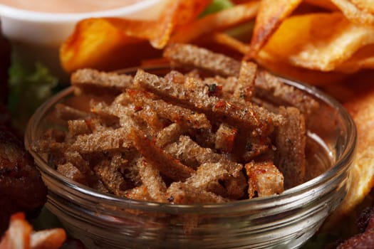 Bowl with appetizing spicy rye crackers, close-up