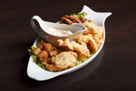 Dish with meat and fish appetizers on wooden background, close-up