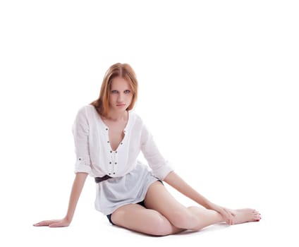 Pretty slim model with red hair posing in studio, isolated on white