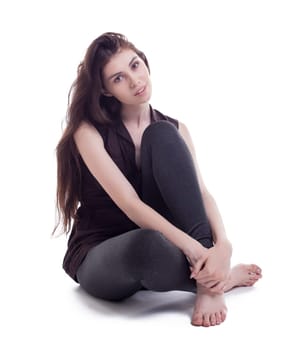 Beautiful brunette with long hair sits in studio, isolated on white