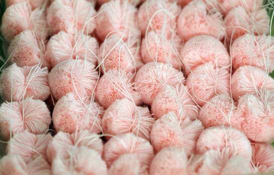 Fluffy pink pompoms for baby clothes, close-up