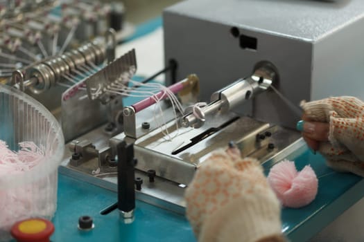 Production of knitted pompoms on factory, close-up