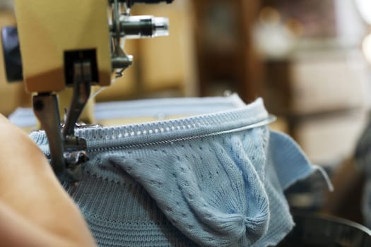 Image of machine knitting blue children's cap, close-up