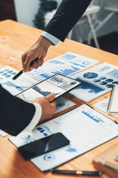 Closeup busy analyst team discussing financial data on digital dashboard, analyzing chart and graph using data science software display on a laptop screen. Business intelligence and Fintech. Fervent