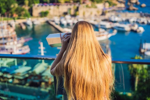 Woman tourist in Old town Kaleici in Antalya. Turkiye. Panoramic view of Antalya Old Town port, Taurus mountains and Mediterrranean Sea, Turkey.