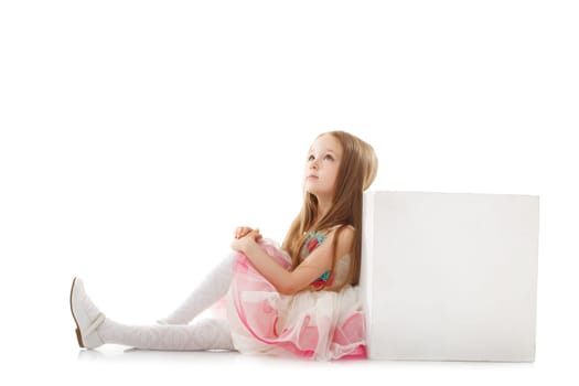 Dreamy little girl posing with cube in studio, isolated on white