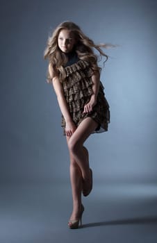 Young curly model posing in leopard print dress, close-up