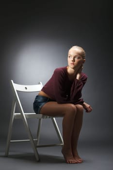 Thoughtful model posing in stylish casual clothes, on gray background