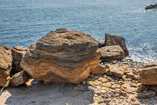 Shell rock boulders on the seashore on the Wild Beach in Odessa, Ukraine, on a sunny spring day