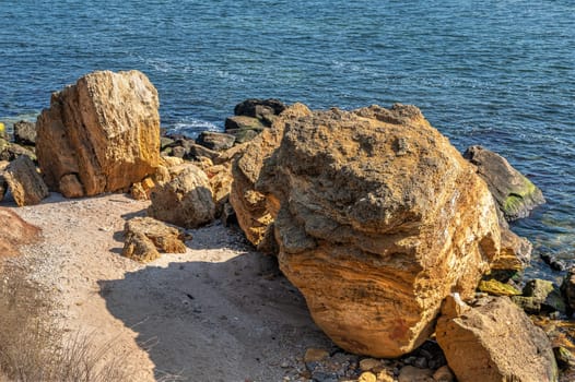 Shell rock boulders on the seashore on the Wild Beach in Odessa, Ukraine, on a sunny spring day